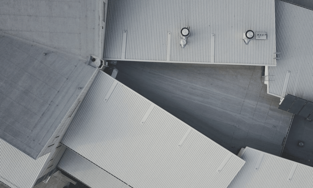 Business owner reviewing commercial roof maintenance contract with technician—get proactive with annual roofing care to protect your property and budget wisely.