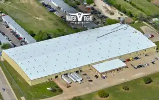 Aerial view of a large white flat roof illustrating The Cost of Delaying Roof Repairs in Q1 and the value of budgeting and planning early.